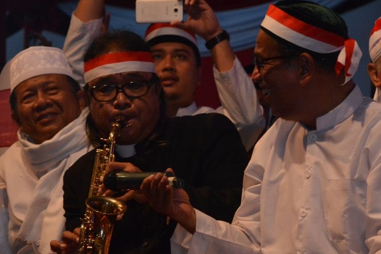 Romo Budi meniup saksofon mengiringi Habib Luthfi dan umat yang menyanyikan lagu   Syiir Padang Bulan dan  Cinta Tanah Air di kegiatan Tausiyah Kebangsaan  di Bundaran Tugu   Muda Semarang, Senin (14/8/2017) malam.