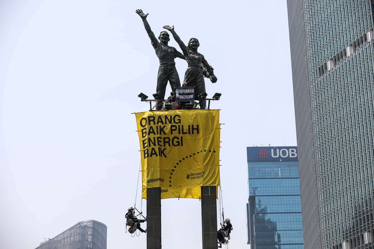 Aktivist dari greenpeace memanjat Monumen Selamat Datang atau patung Bundaran Hotel Indonesia, Jakarta Pusat, Rabu (23/10/2019). Mereka membentangkan spanduk kuning bertuliskan Orang Baik Pilih Energi Baik dan Lawan Perusakan Hutan #ReformasiDikorupsi.