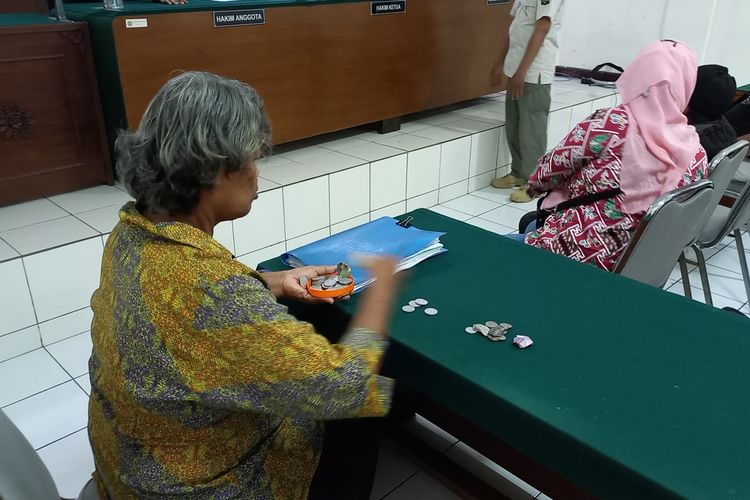 Hartinah saat menghitung uang tabungannya setelah sidang putusan OTT buang sampah sembarangan, Rabu (13/9/2023).