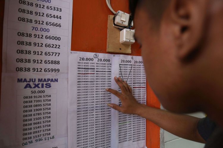 Seorang warga terlihat sedang memilih nomor handphone di salah satu gerai di kawasan Bumi Serpong Damai, Tangerang, Banten, Selasa (7/11/2017). Pemerintah mewajibkan registrasi ulang SIM card bagi para pengguna telepon seluler hingga 28 Februari 2018 dengan memakai nomor NIK dan kartu keluarga (KK). 