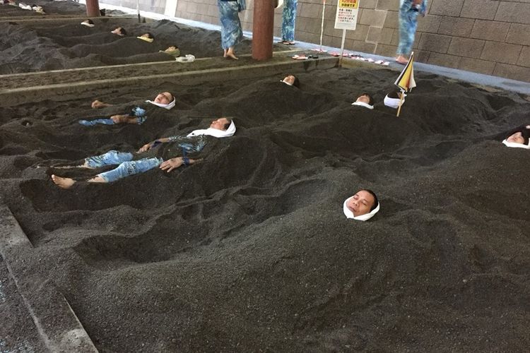 Pemandian pasir panas alami di Onsen Ibusuki Saraku, Prefektur Kagoshima di Pulau Kyushu, Jepang. Tampak pengunjung dikubur di dalam pasir panas. Dua orang di antaranya sudah menggeliat keluar, sehingga separuh padan mereka sudah terlihat. Foto pada Kamis (22/11/2017).