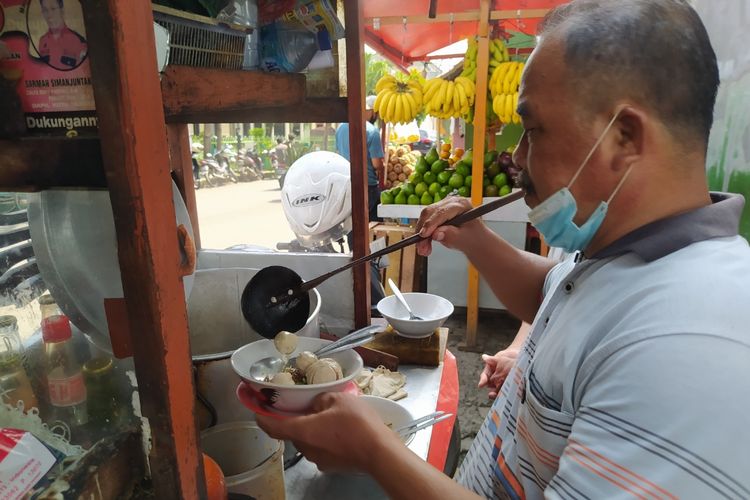 Sosok penjual bakso Rosyid Suryadi yang tengah melayani salah satu pembeli di Jalan Taman Makam Pahlawan Taruna, Kota Tangerang, Banten, Senin (25/1/2021) sore.