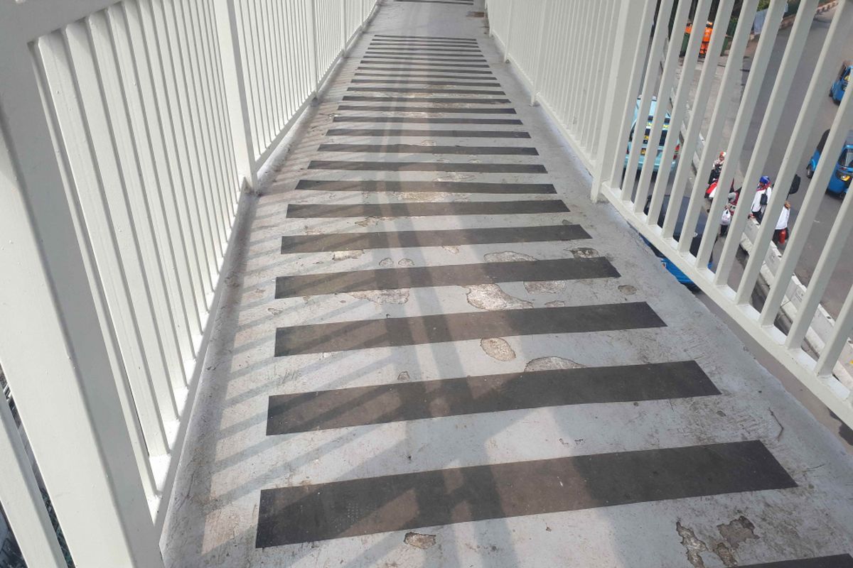 Kondisi lantai ramp skybridge Tanah Abang yang menjadi akses masuk dari Stasiun Tanah Abang tampak mengelupas pada beberapa bagian. Foto diambil Jumat (11/1/2019).