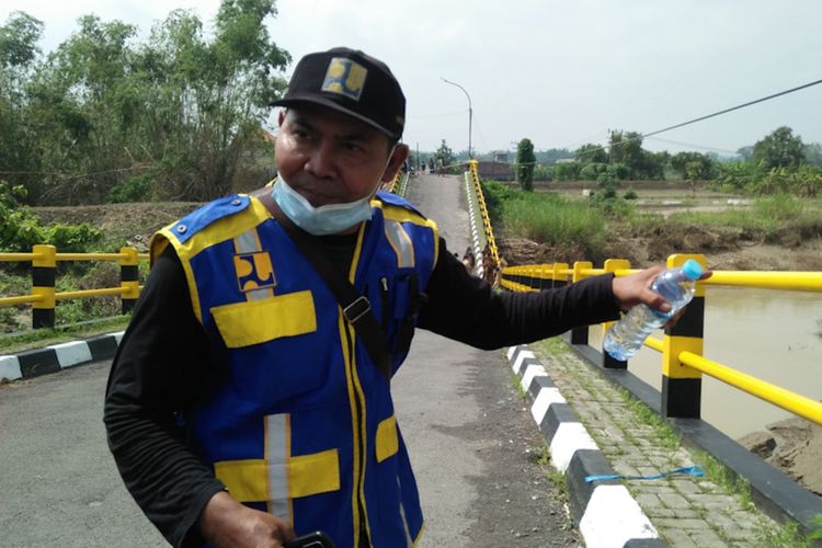Perwakilan OP SDA 04 BBWS Bengawan Solo Kali Lamong, Kardi, saat memberikan keterangan kepada awak media di lokasi ambruknya Jembatan Kacangan, Senin (20/12/2021).