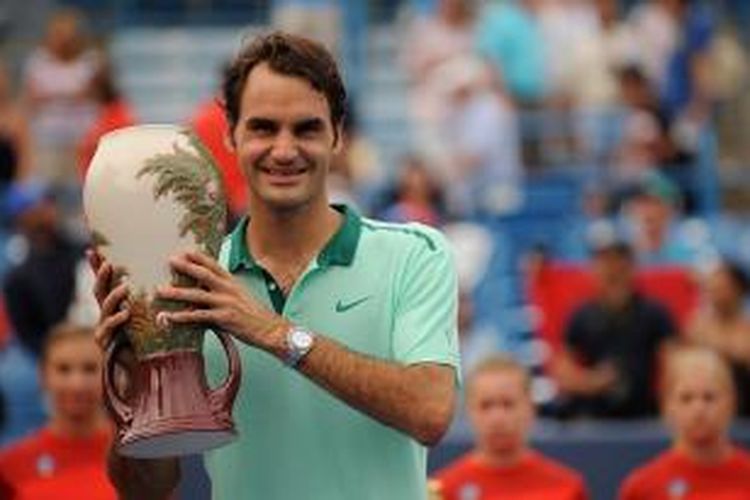 Petenis Swiss, Roger Federer, berpose dengan trofi juara Western & Southern Open setelah mengalahkan petenis Spanyol, David Ferrer, pada laga final di Linder Family Tennis Center, Cincinnati, Minggu (17/8/2014). Federer menang 6-3, 1-6, 6-2.
