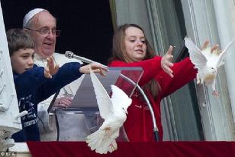 Paus Fransiskus diapit dua orang anak yang melepaskan dua ekor burung merpati saat D0a Angels di Lapangan Santo Petrus, Vatikan, Minggu (26/1/2014).

