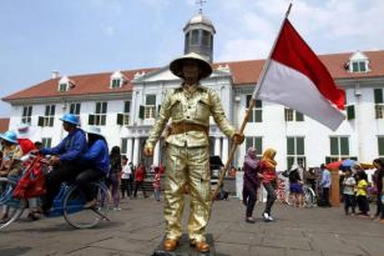 Manusia patung menghibur pengunjung di lapangan Taman Fatahillah di kawasan Kota Tua Jakarta Barat, Rabu (30/7/2014). Dua hari setelah lebaran, kawasan Kota Tua dipenuhi warga yang mengisi masa liburan bersama keluarga. 