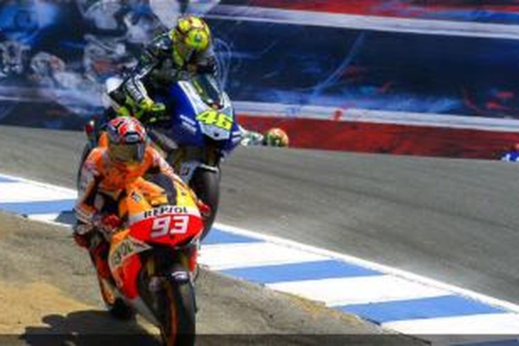 Pebalap Repsol Honda, Marc Marquez (93), melewati pebalap Yamaha Factory Racing, Valentino Rossi (46), pada lap empat di tikungan Corkscrew, Sirkuit Laguna Seca pada balapan GP Amerika Serikat, Minggu (21/7/2013).