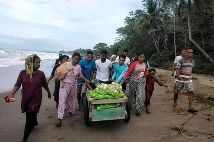 Puluhan warga Desa Desa Misinh, Kecamatan Kilmuri, Kabupaten Seram Bagian Timur membawa seorang warga yang sakit dengan gerobak menuju puskesmas di Kilmuri, Minggu (21/2/2021)