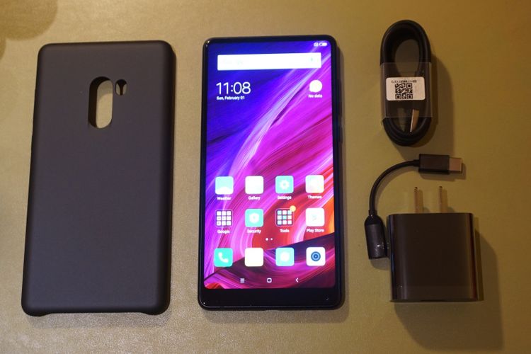 Xiaomi Mi mix 2 dengan casing dan aksesori pendukungnya, kabel charger USB Type-C dan konverter audio.