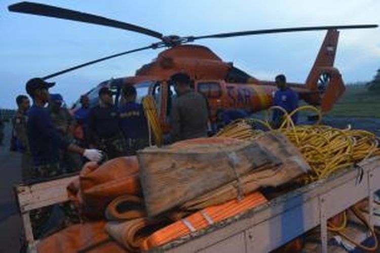 Petugas Basarnas memasukkan lifting bag atau balon udara ke helikopter untuk dibawa ke KRI Banda Aceh di perairan Kalimantan Tengah, Jumat (9/1/2015). Alat tersebut rencananya akan digunakan untuk mengangkat bagian ekor pesawat AirAsia QZ8501.