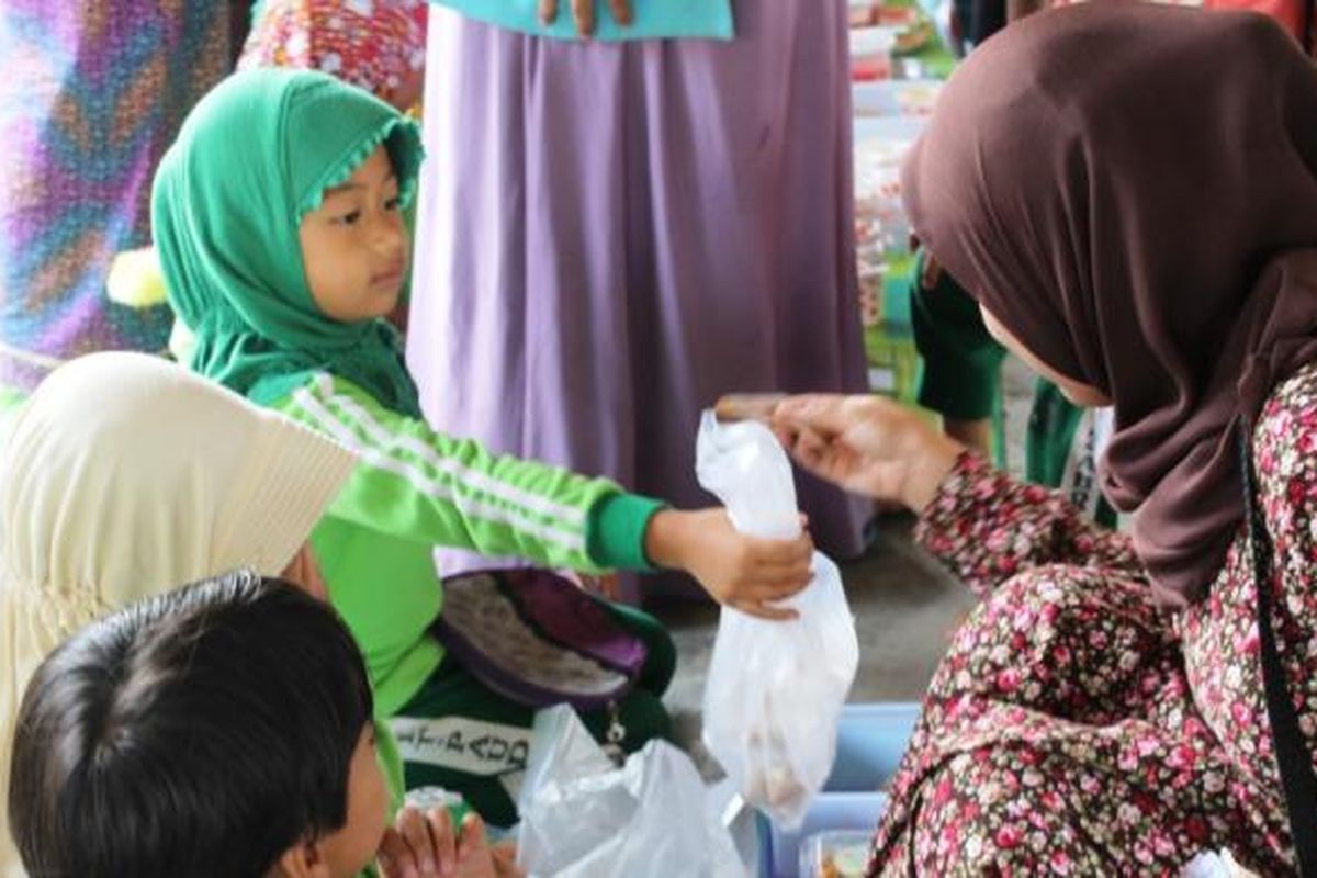 Seorang pengunjung sedang membeli jajanan kepada para pedagang cilik yang merupakan siswa PAUD TK IT Az Zahra, Takengon, Aceh Tengah, Aceh, Sabtu (5/3/2016).