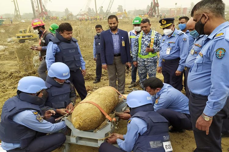Anggota unit penjinak bom memeriksa sebuah bom era perang berbentuk silinder yang ditemukan terkubur di lokasi pembangunan Bandara Internasional Hazrat Shahjalal di Dhaka, ibu kota Bangladesh, pada 9 Desember 2020. Bom silinder itu berbobot sekitar 250 kg, menurut Inter Service Public Relations (ISPR).