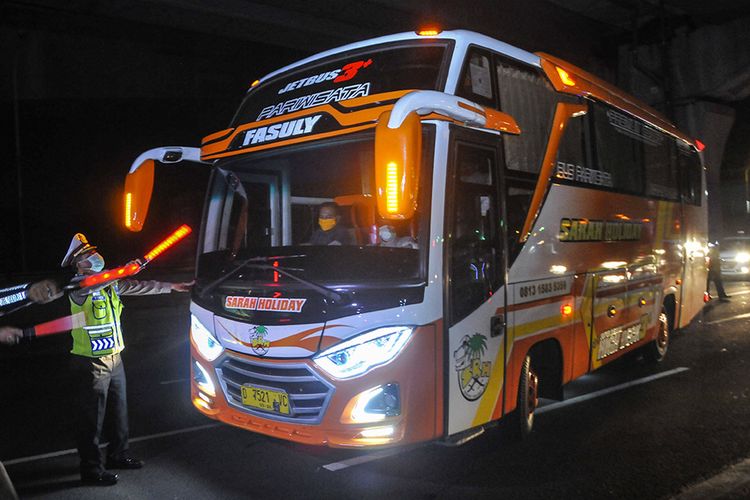 Polisi menghalau mobil bus yang membawa pemudik di Tol Jakarta-Cikampek untuk keluar ke Gerbang Tol Cikarang Barat, Kabupaten Bekasi, Jawa Barat, Jumat (24/4/2020).  Akses transportasi mobil pribadi dan bus angkutan penumpang dari Tol Jakarta-Cikampek menuju Karawang ditutup mulai Jumat (24/4/2020) jam 00.00 WIB.