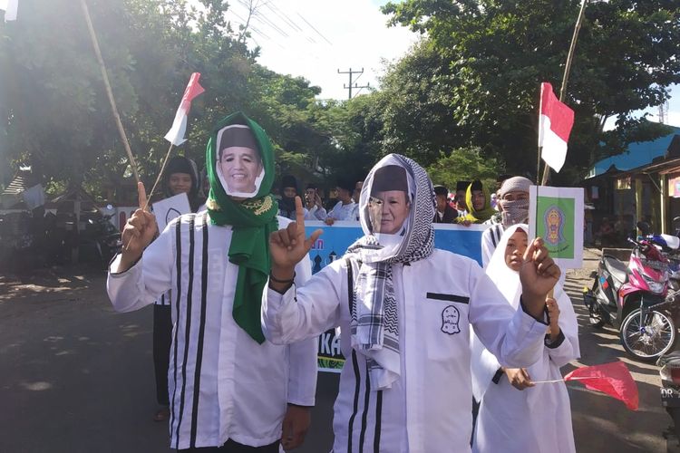 Dua pemuda mengenakan topeng Jokowi dan Prabowo sebagai simbol perdamaian, saat pawai taaruf menyambut bulan suci Ramadhan