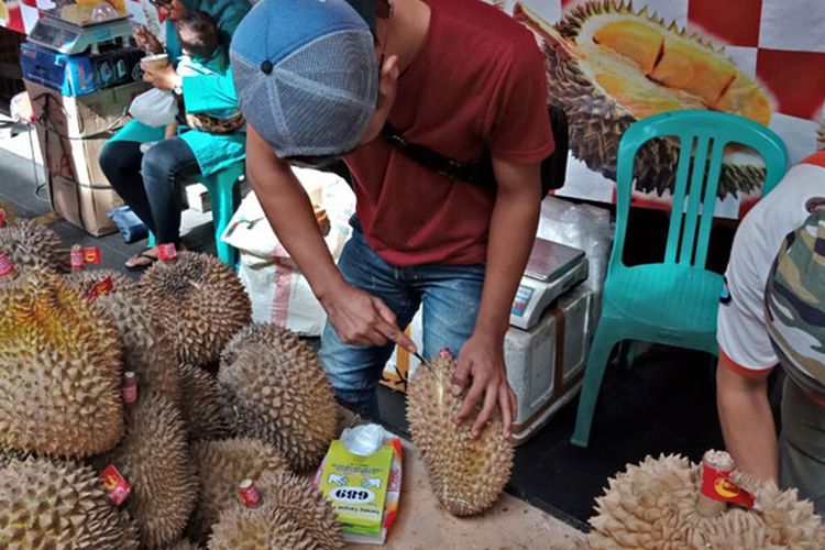 Teknik mengupas durian yang diperagakan salah satu penjualnya di bazar durian Blok M Square, Jakarta, Rabu (7/3/2018).