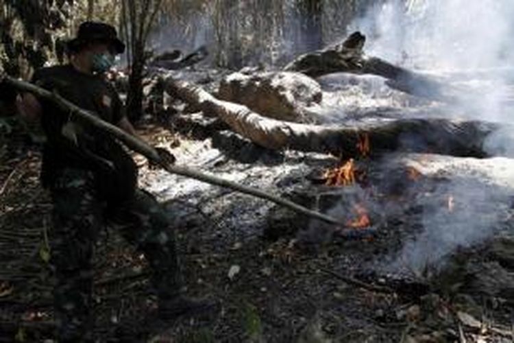 Anggota Batalion Marinir Pertahanan Pangkalan Bitung berusaha memadamkan titik api yang membakar ribuan hektar hutan adat dan lahan perkebunan warga di Pulau Bangka, Minahasa Utara, Sulawesi Utara. Kebakaran tersebut telah terjadi selama sepakan ini.