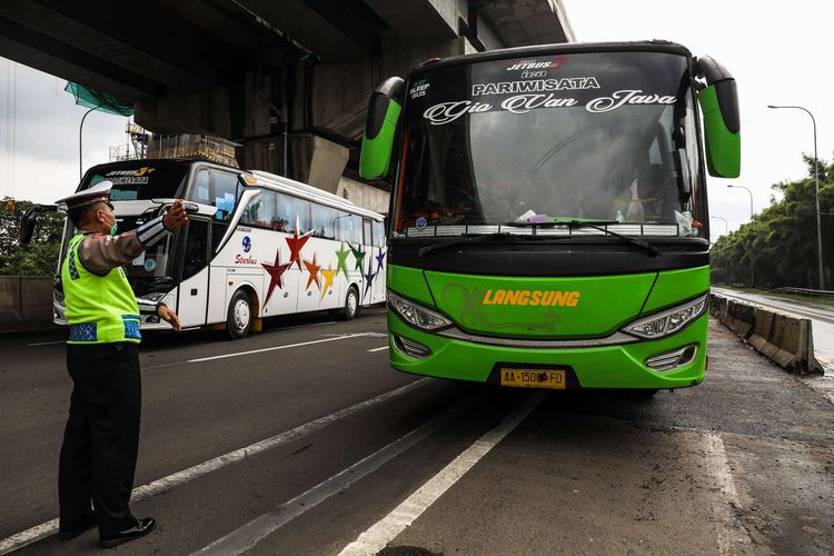 bPolisi menghalau mobil bus yang membawa penumpang di jalan tol Jakarta-Cikampek untuk keluar ke Gerbang tol Cikarang Barat, Kabupaten Bekasi, Jawa Barat, Jumat (24/4/2020). Larangan mudik mulai diberlakukan 24 April 2020 pukul 00.00 WIB. Polda Metro Jaya melarang kendaraan pribadi baik motor atau mobil dan kendaraan umum berpenumpang keluar dari wilayah Jabodetabek. Pemeriksaan dan penyekatan kendaraan tersebut akan dilakukan di 18 titik pos pengamanan terpadu dan pos-pos check point di jalur tikus dan perbatasan.