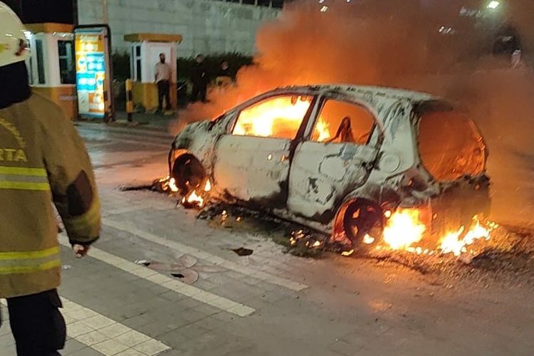 Mobil Honda Brio terbakar di Jalan Jenderal Sudirman depan Mal Ratu Plaza, Tanah Abang, Jakarta Pusat, Minggu (24/4/2022), api diduga muncul berasal dari korsleting listrik dari mesin.