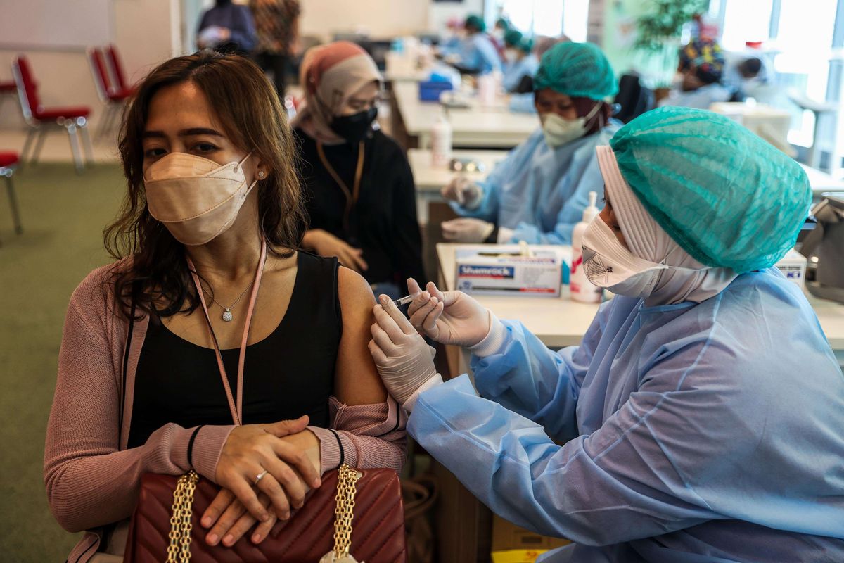 Tenaga medis menyuntikkan vaksin Covid-19 Pfizer booster saat pelaksanaan vaksinasi dosis ketiga di Kantor OJK, Wisma Mulia 2, Jakarta Selatan, Minggu (23/1/2022). Pemerintah mulai mendistribusikan vaksin Covid-19 booster atau vaksin dosis ketiga kepada masyarakat umum. Vaksin booster bertujuan untuk memperkuat imunitas masyarakat di tengah serbuan virus corona varian Omicron di Indonesia.