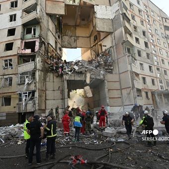 Petugas Layanan Darurat Ukraina menyisir puing-puing di apartemen yang hancur dalam serangan udara Rusia di Kharkiv, Ukraina, Kamis (24/10/2024).