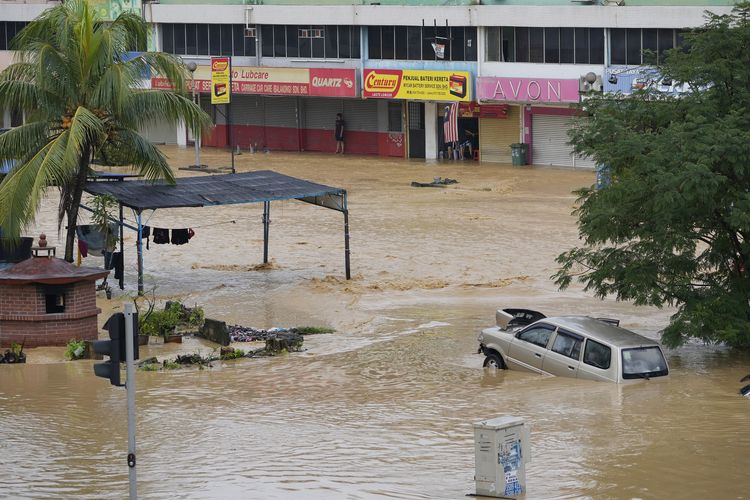 Seorang warga yang terjebak banjir menunggu pertolongan di Hulu Langat, luar Kuala Lumpur, Malaysia, Minggu (19/12/2021). Kuala Lumpur dan sekelilingnya direndam banjir akibat hujan deras dua hari beruntun, mengakibatkan ribuan orang dievakuasi dan banyak akses jalan terputus.