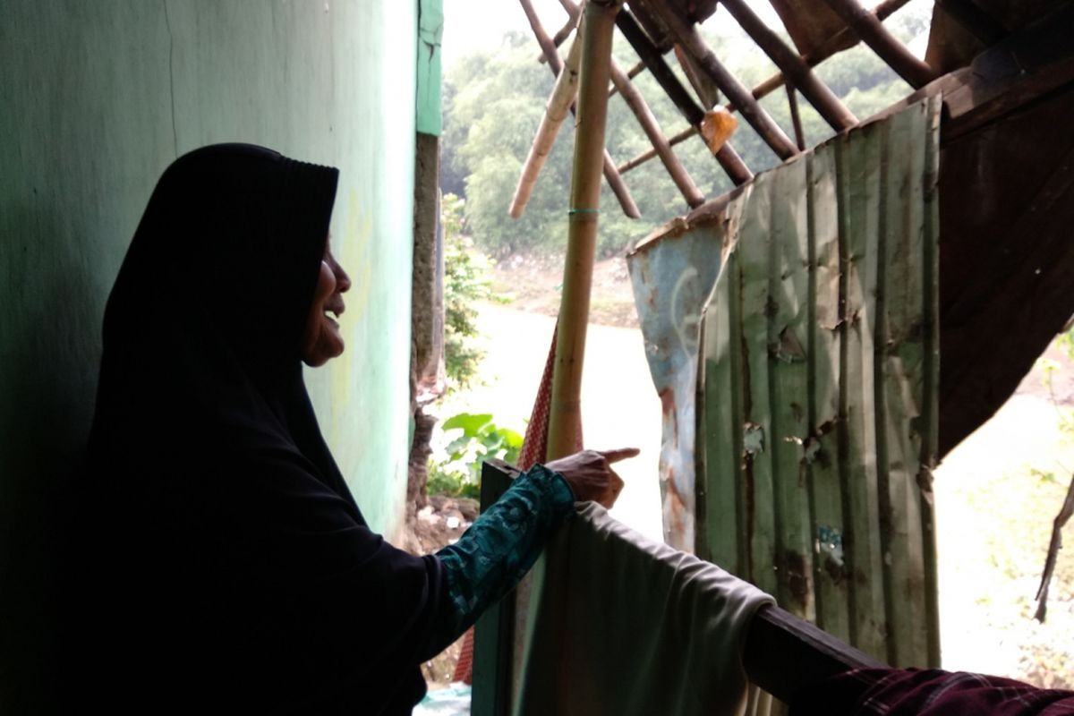 Isah, warga Teluk Pucung, Bekasi, memperlihatkan kondisi rumahnya yang sudah hancur di tepi Kali Bekasi, Kamis (1/3/2018).