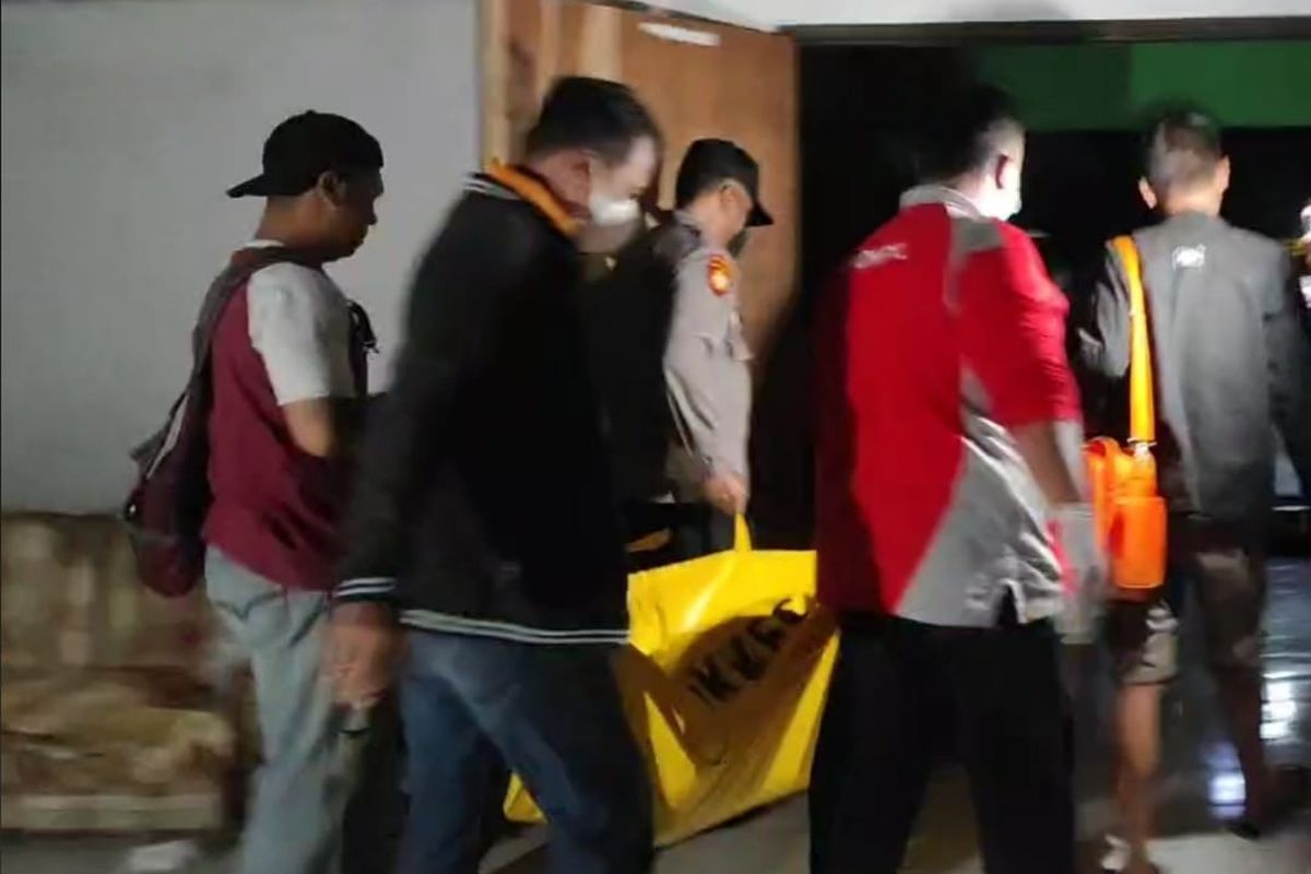 EVAKUASI—Petugas Polres Madiun Kota mengevakuasi jasad Slamet, seorang tukang becak yang ditemukan tewas di sebuah gedung kosong di belakang Kantor KPU Kota Madiun, Jawa Timur, Selasa (12/7/2022) malam. 