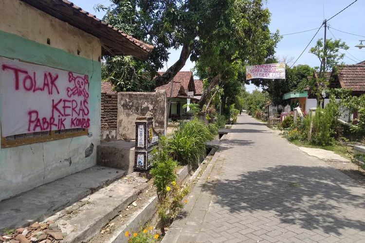 Spanduk protes warga atas bau busuk dari pabrik pupuk organik bertebaran di sepanjang jalan Dusun Templek, Desa Tanjungkalang, Kecamatan Ngronggot, Nganjuk, Senin (11/10/2021).