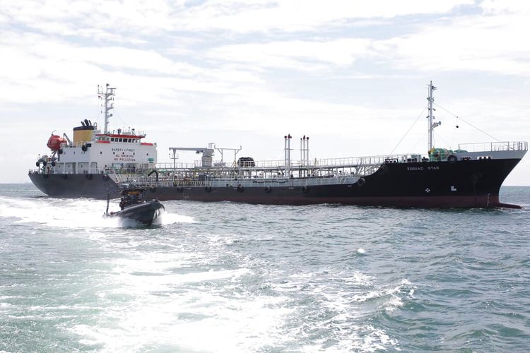 Dalam foto tak bertanggal yang dirilis Angkatan Laut Indonesia ini, sebuah kapal angkatan laut berlayar melewati kapal tanker MT Zodiac Star berbendera Panama yang berlabuh di perairan Kepulauan Riau, Indonesia pada Rabu (1/9/2021).