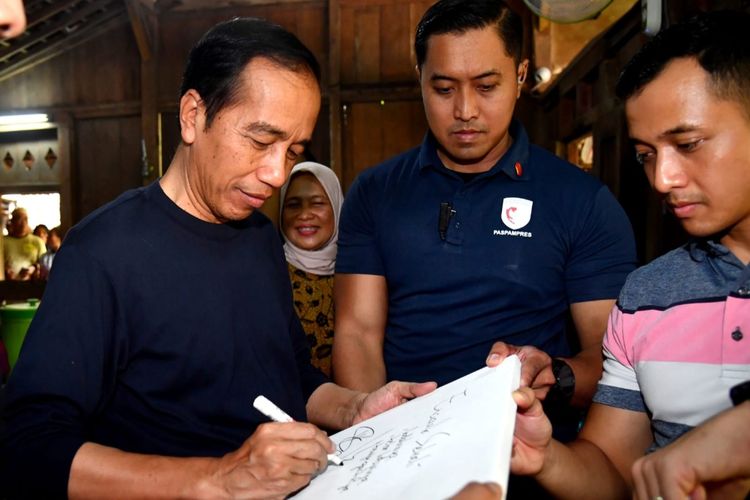Presiden Joko Widodo saat menuliskan kesan-kesannya usai menikmati sajian kuliner di Warung Kopi Klotok yang ada di Jalan Kaliurang, Kabupaten Sleman, Daerah Istimewa Yogyakarta pada Sabtu (3/6/2023).