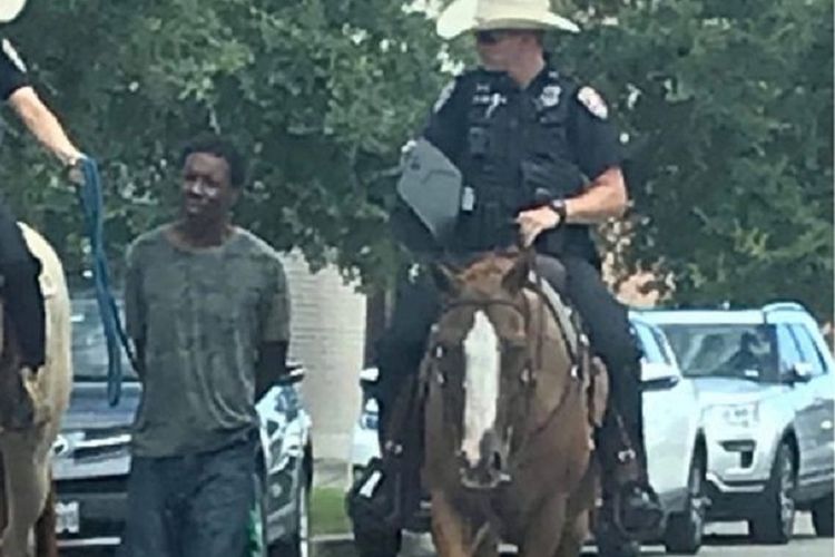 Inilah gambar yang memperlihatkan seorang pria kulit hitam digelandang oleh dua polisi berkuda Texas, AS, dengan kondisi terikat tali.