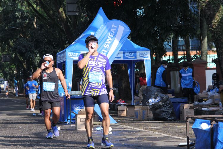 Para pelari marathon di Pocari Sweat Run Indonesia 2022, ketika mendapatkan asupan air minum melewati Jl Padjadjaran Kota Bandung, Minggu (24/7/2022).