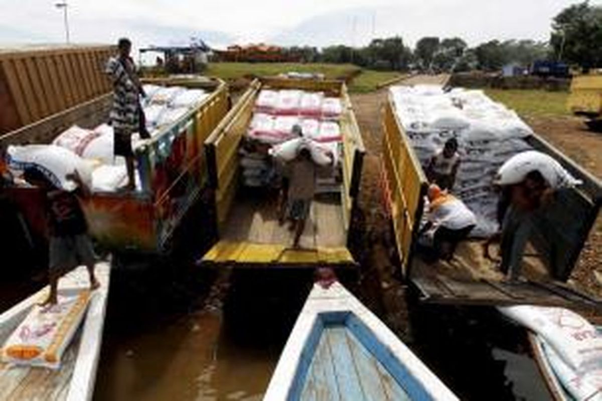 Buruh pikul memuat pakan ikan ke dalam perahu motor di terminal air Jangari, Desa Bobojong, Kabupaten Cianjur, Jawa Barat, Sabtu (26/3/2011). Para buruh yang mampu memikul 10 ton pakan per hari ini dibayar Rp 14.000 per ton.