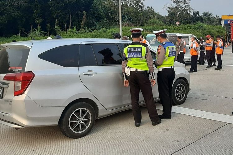 Police stop and turn back a vehicle suspected of carrying holiday travelers outside Semarang, Central Java on Thursday (6/5/2021).