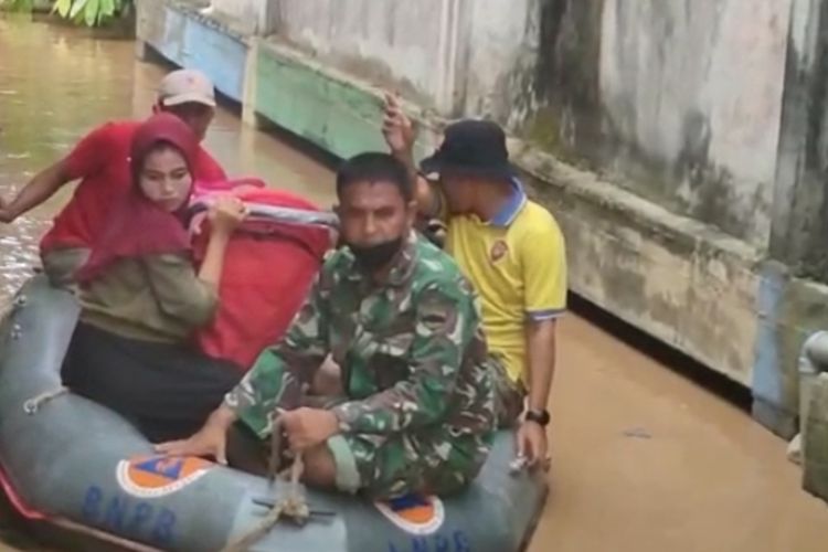 Petugas mengevakuasi warga yang dilanda banjir di Kecamatan Rambah, Kabupaten Rokan Hulu, Riau, Sabtu (1/1/2022).