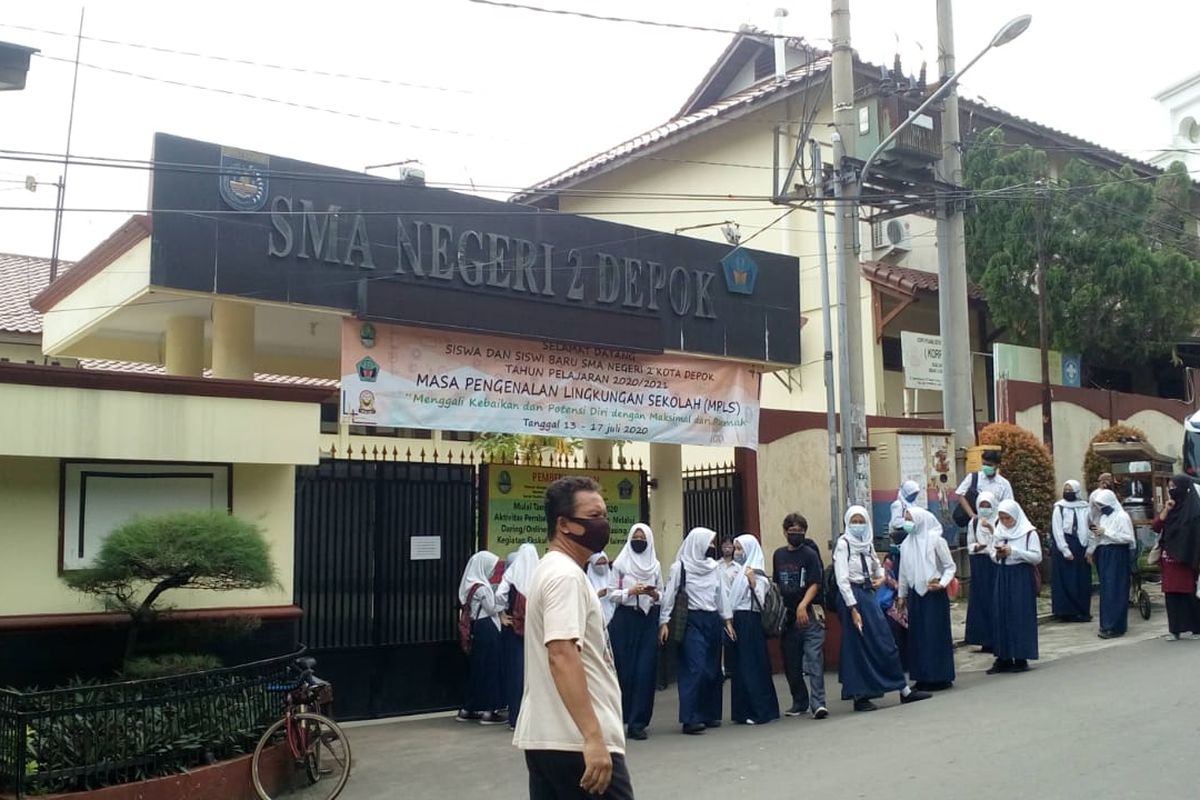 Siswa-siswi tampak berkerumun di SMAN 2 Depok padahal seluruh kegiatan belajar-mengajar telah ditetapkan agar diadakan jarak jauh di tengah pandemi Covid-19.