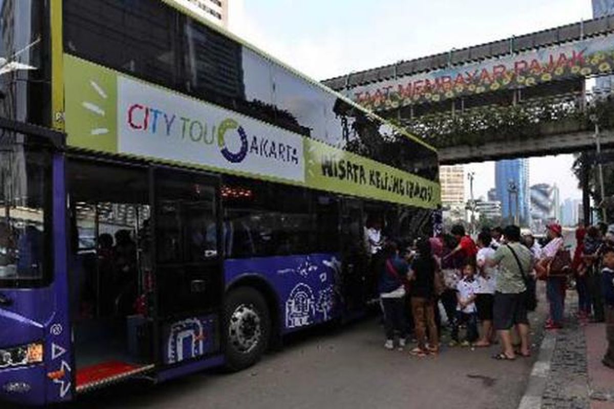 Warga mengantre berebutan naik bus tingkat wisata di Halte Bundaran Hotel Indonesia, Jakarta Pusat, Minggu (2/3/2014). Sebanyak 5 bus tingkat yang dioperasikan belum mampu sepenuhnya melayani warga DKI Jakarta. Pasalnya warga harus rela yang antre berjam-jam untuk bisa naik bis tersebut. 