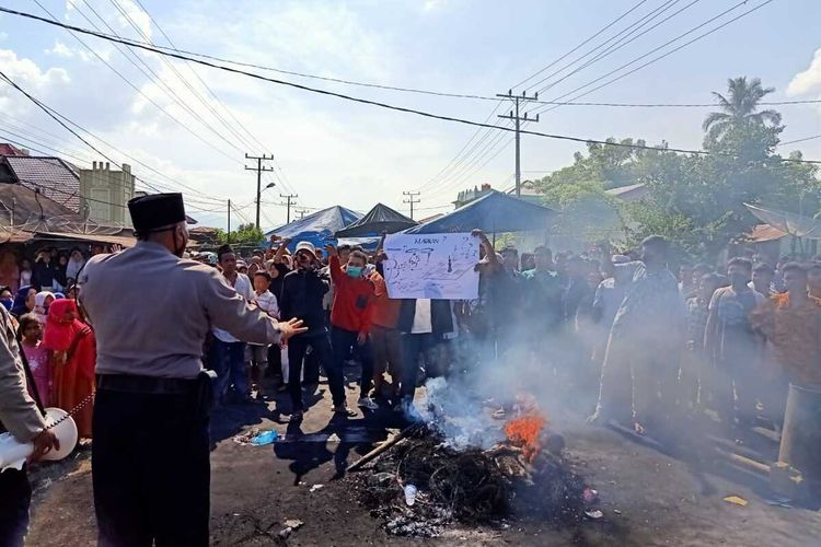 Ratusan warga memblokade jalan nasional yang menghubungkan antara Sumatera Utara dan Sumatera Barat di Desa Mompang Julu, Panyabungan Utara, Mandailing Natal, Senin 29/5/2020). Aksi yang dipicu gara-gara BLT Covid-19 ini mengakibatkan bentrok antar kelompok warga dan aparat keamanan, dan dikabarkan sedikitnya dua unit mobil dibakar serta sejumlah polisi mengalami luka-luka