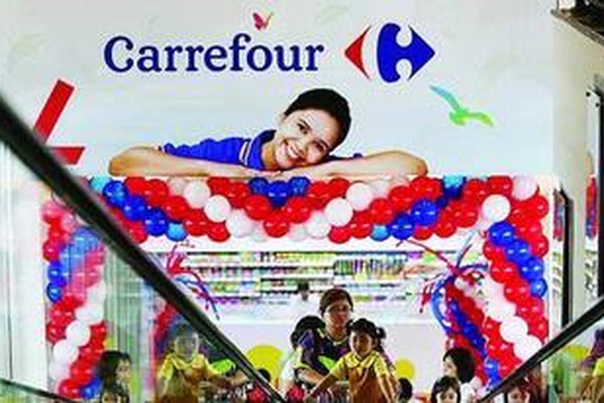 Konsumen seusai berbelanja di gerai Carrefour.