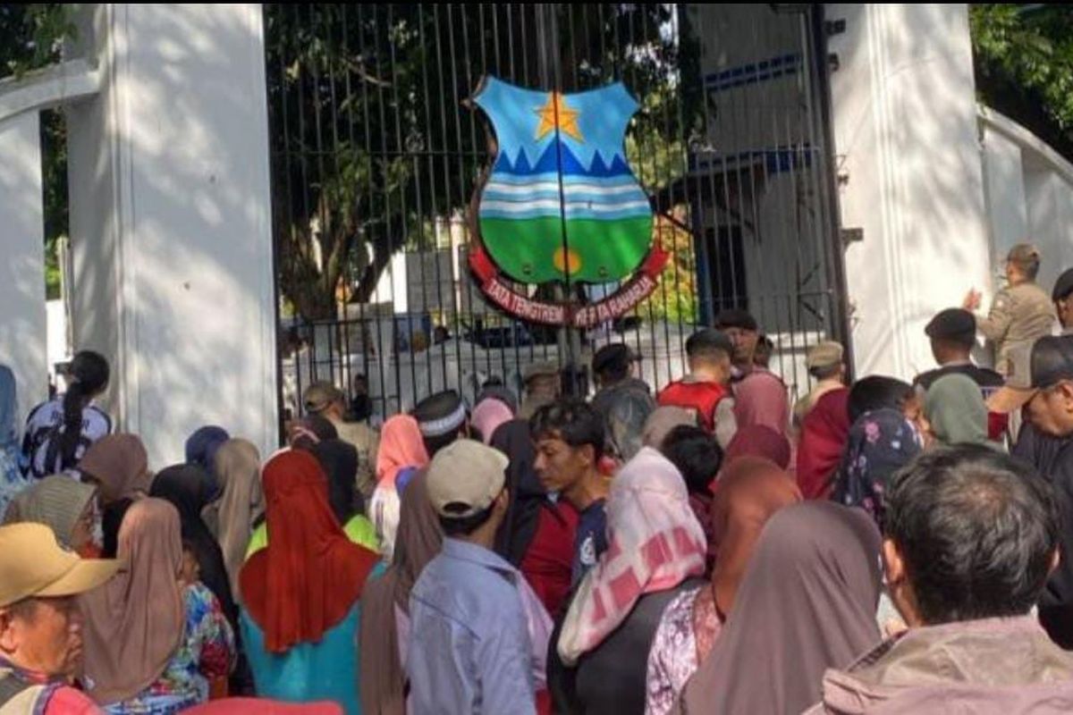Warga mengantre di gerbang pendopo Garut menunggu gelaran makan gratis yang merupakan rangkaian kegiatan pernikahan Wakil Bupati Garut Putri Karlina dan Maula Akbar putra dari Gubernur Jawa Barat Dedi Mulyadi, Jumat (18/7/2025) siang. 3 orang tewas berdesakan sat mengantre makan gratis ini.