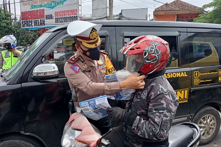 Kasatlantas Polresta Bandung Kompol Rislam Harfiah membuat arus lalu lintas di Kabupaten Bandung membagi-bagikan masker dalam Operasi Lodaya 2022, Rabu, (2/3/2022)