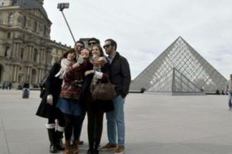 Para pengunjung museum Louvre, Paris mengabadikan momen bersama menggunakan bantuan tongsis. Sejumlah museum internasional sudah melarang penggunaan tongsis karena berpotensi merusak koleksi museum.
