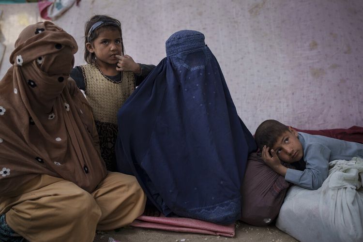 Malalai, tengah, dari provinsi Kunduz, duduk bersama anak-anaknya di kamp pengungsi internal saat mereka menunggu bus untuk pulang, di Kabul, Afghanistan, Sabtu, 9 Oktober 2021. 