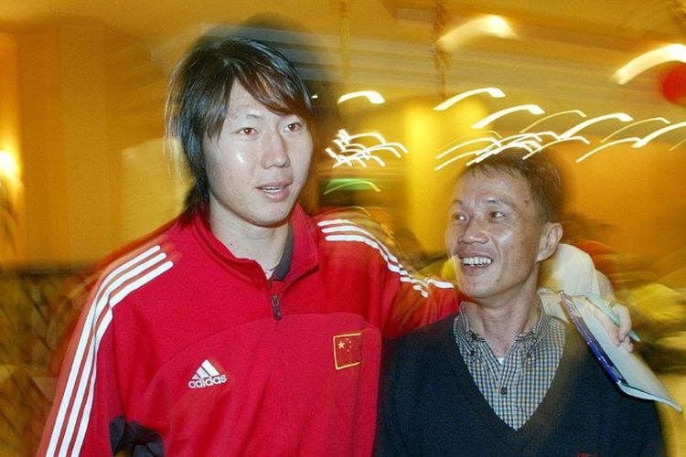 Mantan pemain Everton dan timnas China, Li Tie, bersama penggemar sebelum pertandingan persahabatan melawan Brasil di Guangzhou pada 11 Februari 2003. Terkini, Li Tie divonis penjara seumur hidup setelah membuat pengakuan bahwa ia melakukan penyuapan dan terlibat dalam pengaturan skor pertandingan di negerinya. (Foto oleh PETER PARKS / AFP)