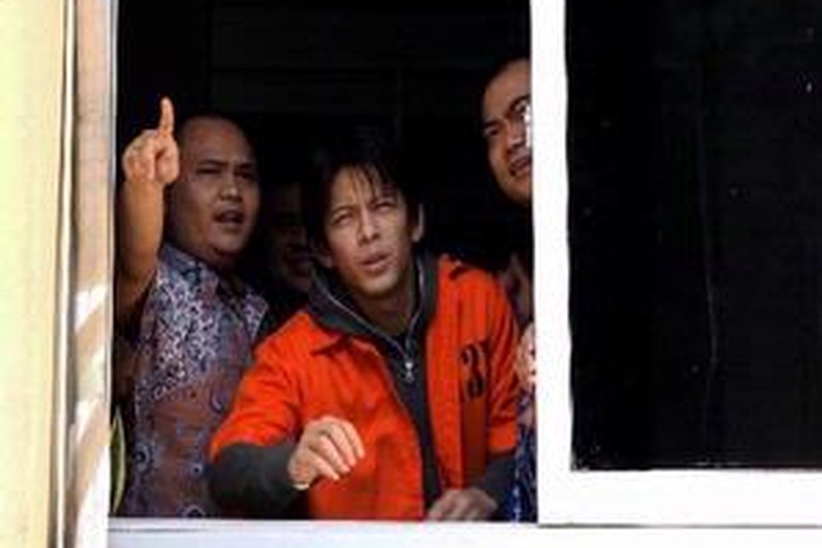Nazriel Irham atau Ariel (tengah) tersangka kasus video porno terlihat mengenakan seragam baju tahanan saat menyapa para fans dari jendela ruang pemeriksaan Bareskrim Mabes Polri, Jakarta, Jumat (25/6/2010). KOMPAS IMAGES/BANAR FIL ARDHI