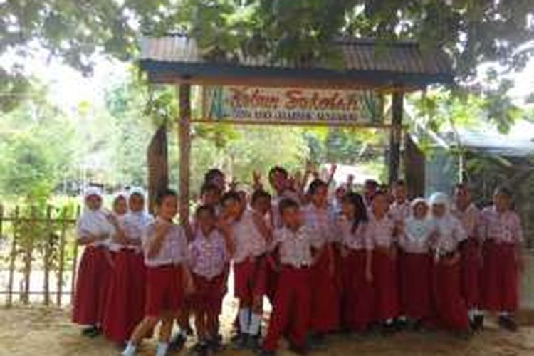 Para siswa SD Negeri Bongan berpose di depan kebun sekolah mereka.