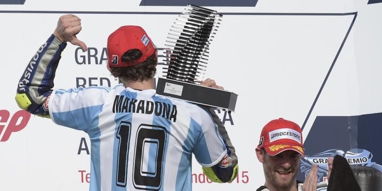 Pebalap Movistar Yamaha asal Italia, Valentino Rossi (kiri), memamerkan kaus bernomor 10 milik Diego Maradona saat naik podium Sirkuit Termas de Rio Hondo setelah finis pertama pada balapan GP Argentina, Minggu (19/4/2015).