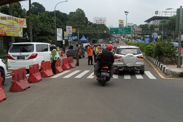 Sejumlah petugas gabungan mengkombinasikan rekayasa lalu lintas berupa ganjil genap dan sistem satu arah atau one way di Jalur Puncak Bogor, Jawa Barat, Minggu (19/9/2021).
