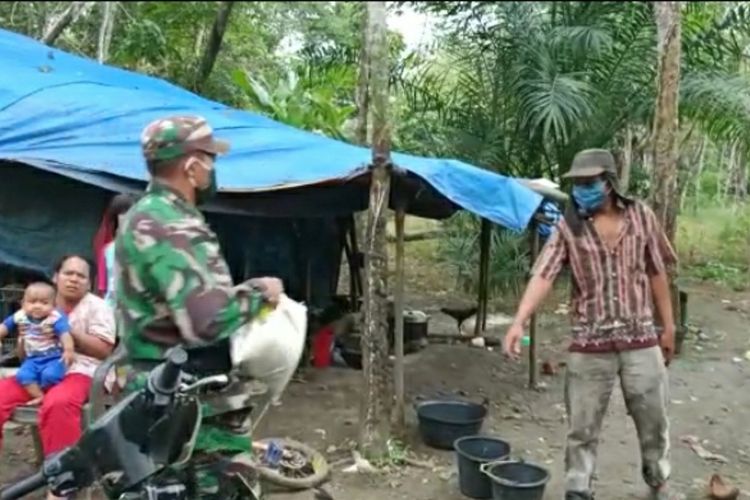 Anggota Koramil 02/Rambah memberikan bantuan beras dan sejumlah uang kepada Suriadi (45), keluarga yang tinggal di gubuk terpal di Desa Rambah, Kecamatan Rambah Hilir, Kabupaten Rohul, Riau, Senin (26/4/2021).